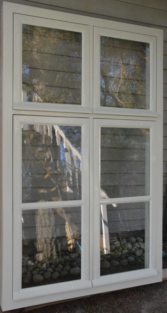 Kuusilasinen, vanhan mallinen ikkuna ja valkoinen karmi. 